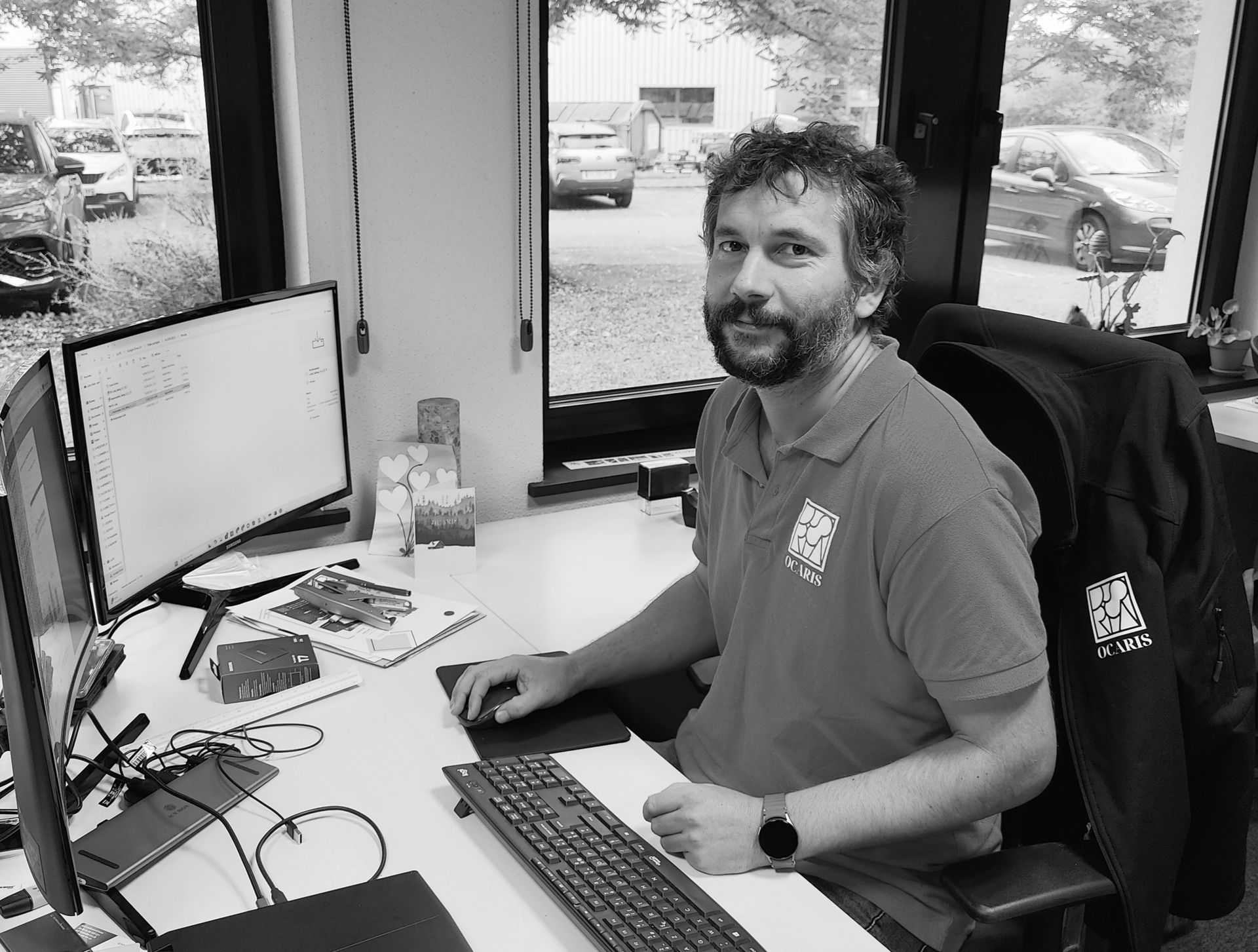 Lorry-Alan Moalic, homme aux cheveux bouclés et à la barbe, regardant la caméra.