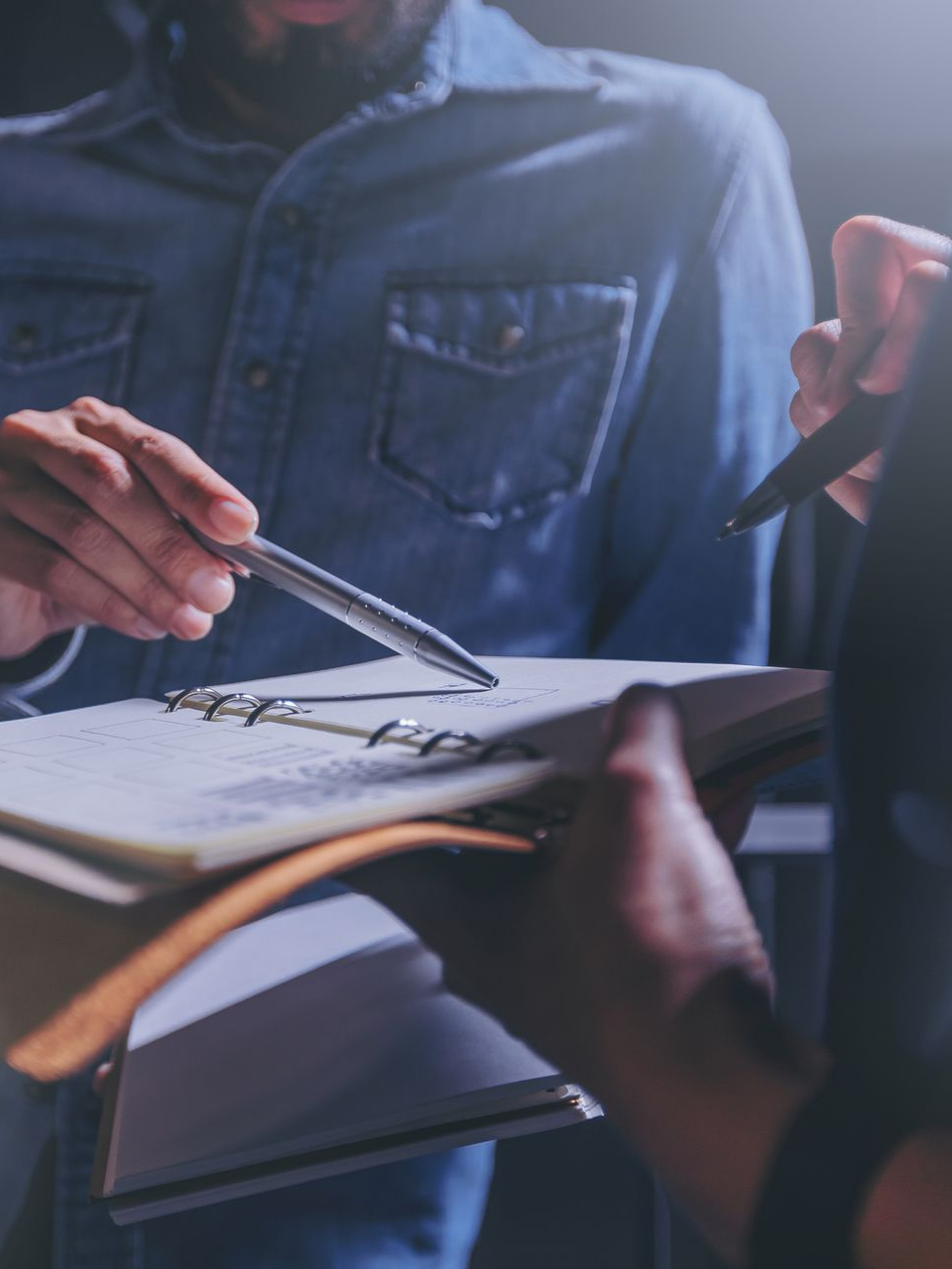 Une personne sélectionne une couleur dans une palette. L'espace de travail comprend un clavier, un casque, un carnet et des marqueurs de couleur.