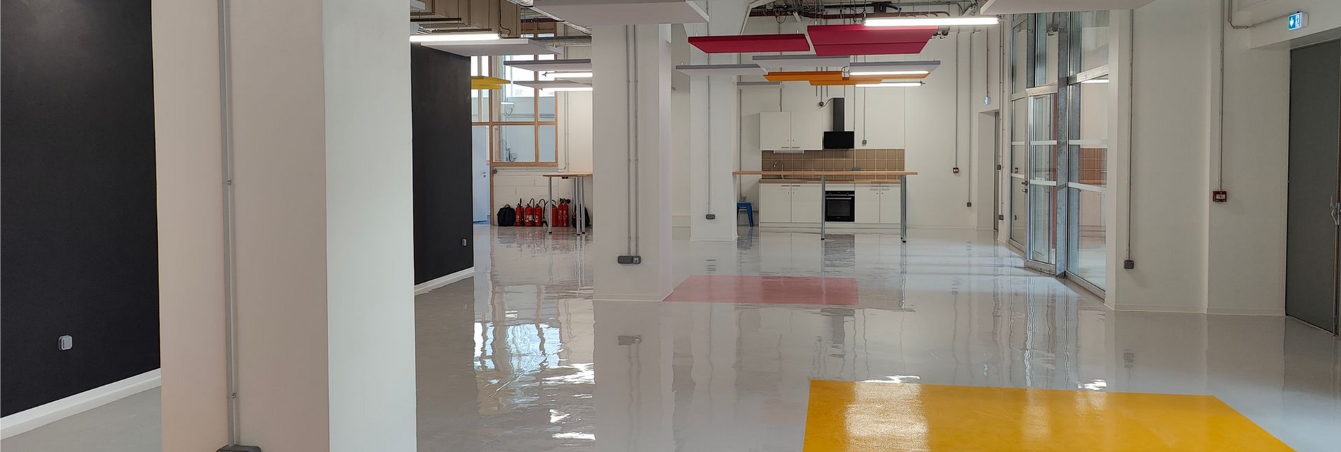 Intérieur spacieux et moderne avec colonnes, sol poli et grande fenêtre.