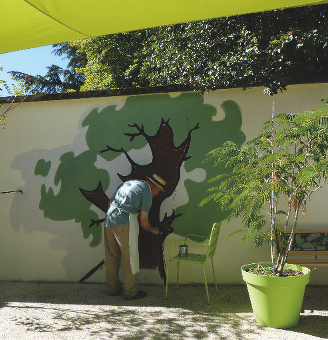 Personne qui paint un arbre sur un mur