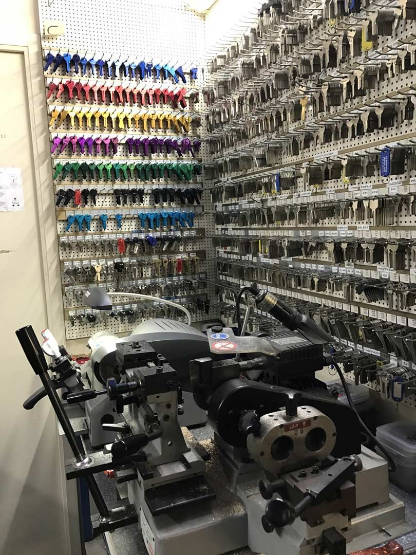 Atelier industriel avec un tour à métaux, des murs équipés de rangements à outils bien organisés et des bacs de couleur