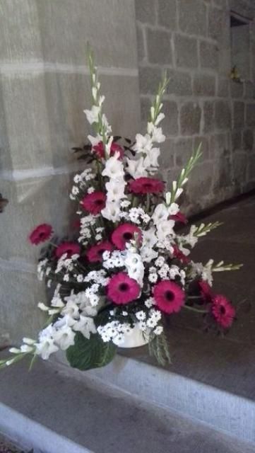 Un bouquet de fleurs roses et blanches devant un mur de briques