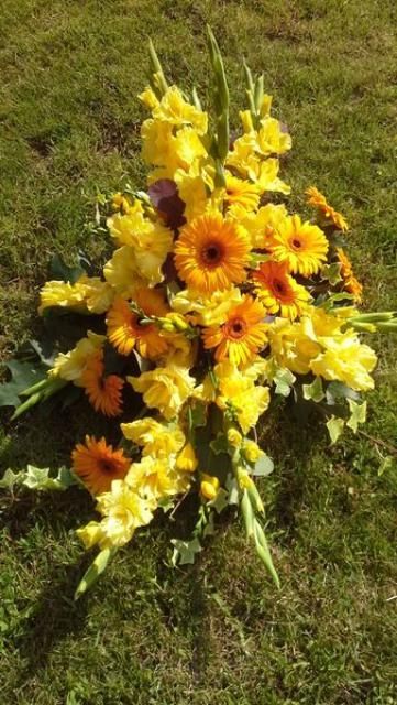 Un bouquet de fleurs jaunes est posé sur l'herbe.