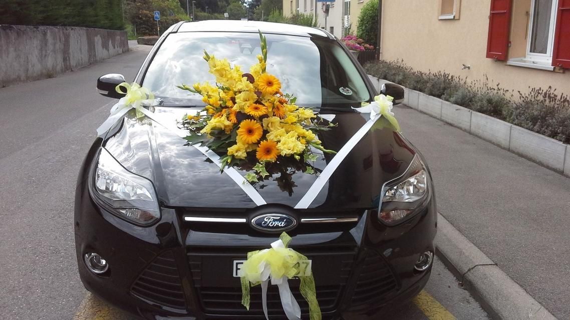 Une voiture Ford noire décorée de fleurs et de nœuds jaunes