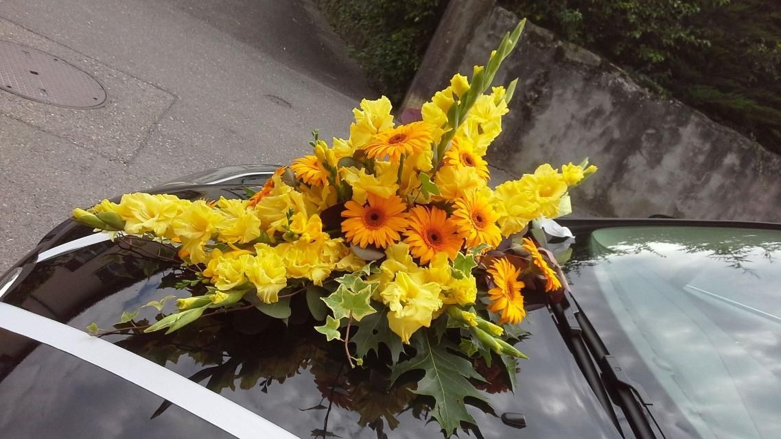 Une voiture noire avec des fleurs jaunes sur le toit