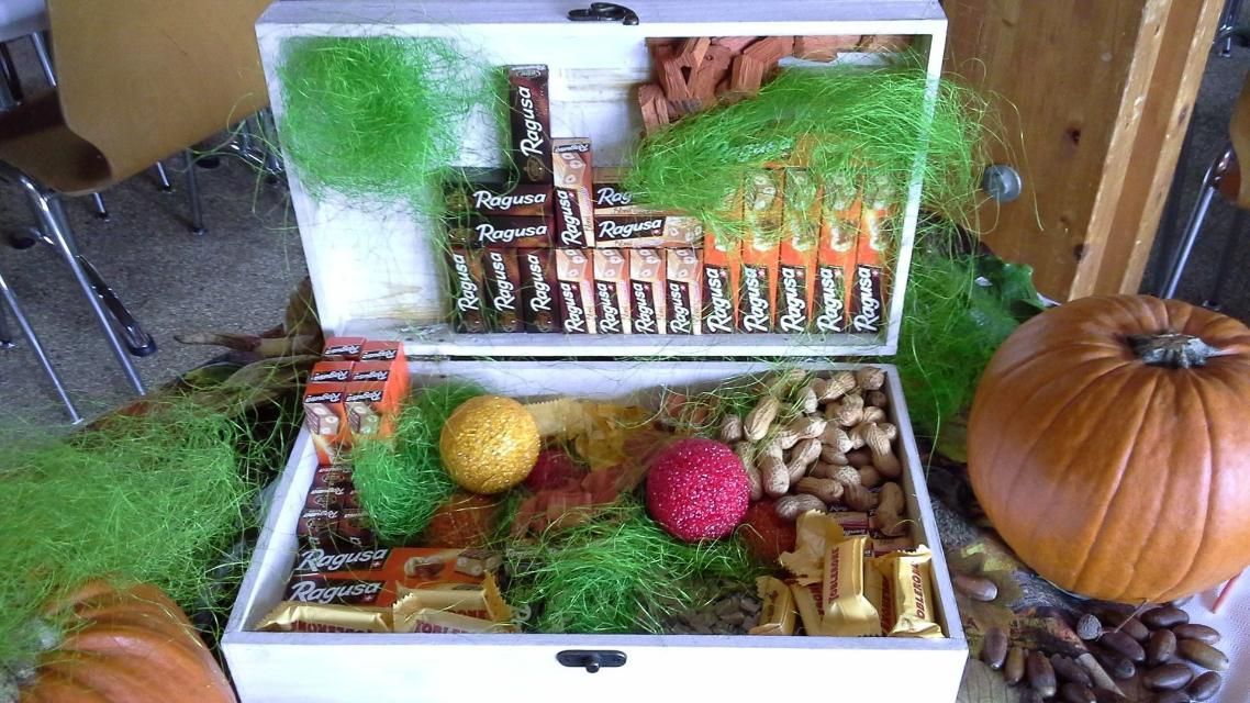 Une valise blanche remplie de collations et une citrouille en arrière-plan