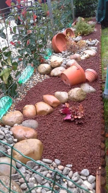 Un jardin rempli de rochers et de plantes en pot.