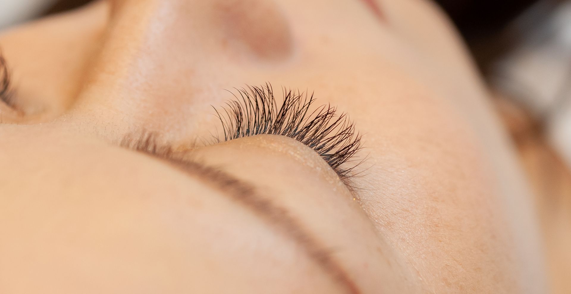 Nahaufnahme von geschlossenen Augen mit langen, dunklen Wimpern.