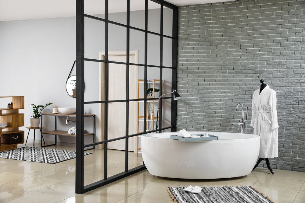 Un baño con bañera y pared de ladrillo.