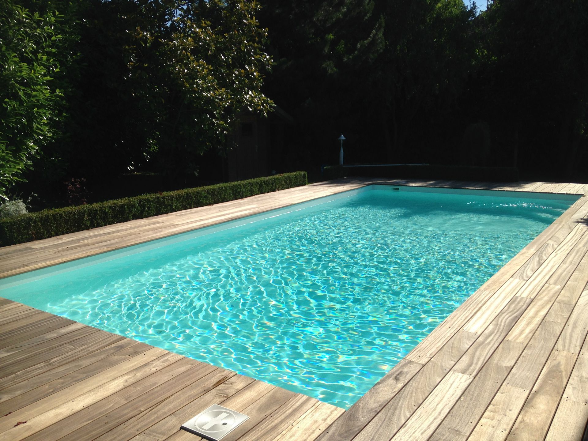 Photo d'une piscine enterrée et d'un tour de piscine en bois