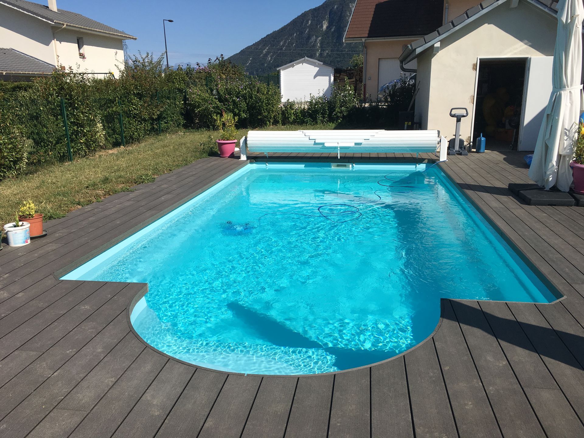 Photo d'une piscine remplie et d'un volet roulant hors-sol ouvert