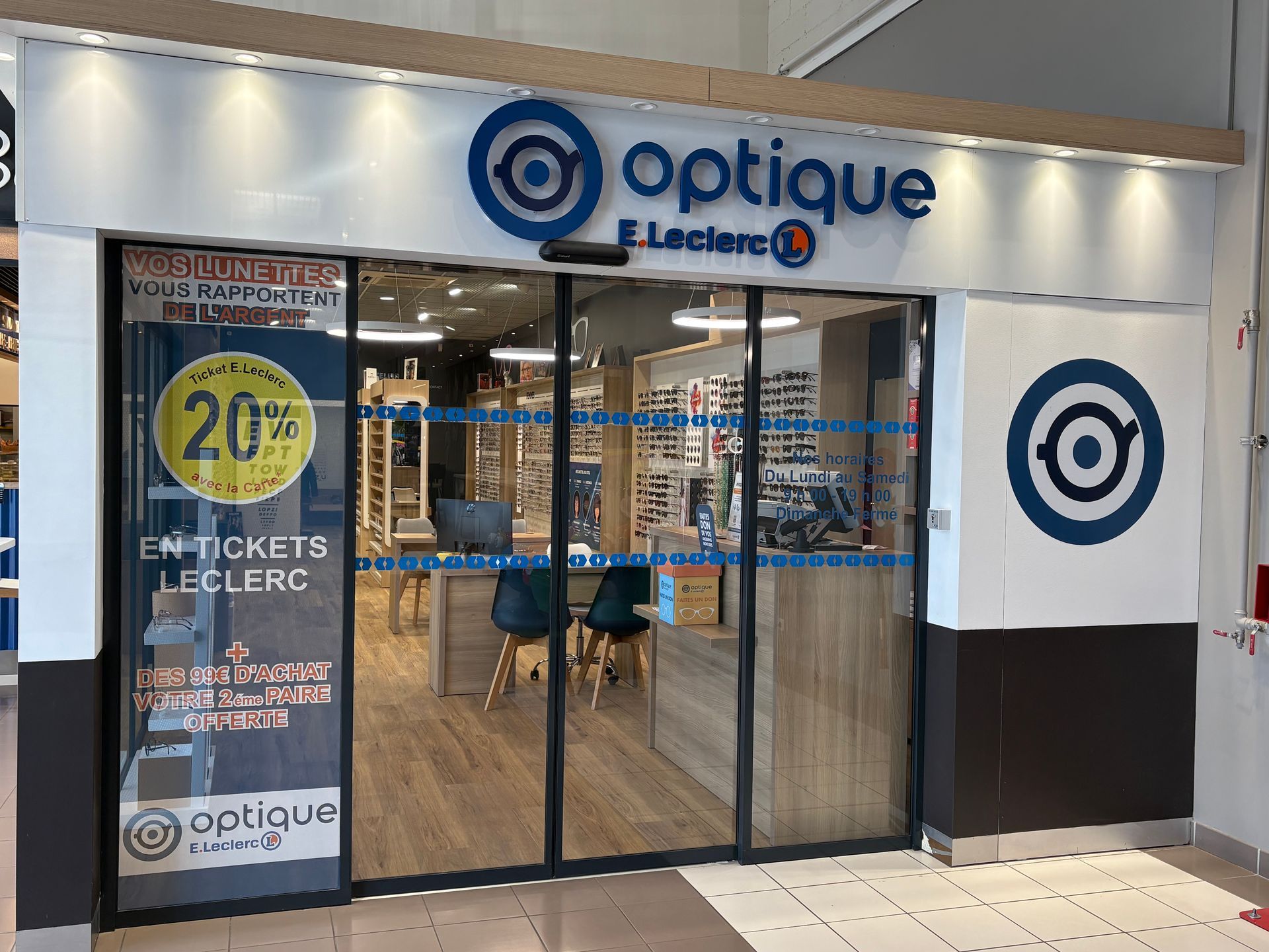 Devanture du magasin d'optique E.Leclerc avec l'offre : vos lunettes vous rapportent de l'argent, 20 % ticket E.Leclerc sur la carte + dès 99 € d'achat votre 2e paire OFFERTE. 