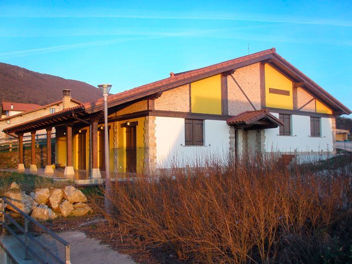 Una casa blanca y amarilla con techo de tejas rojas