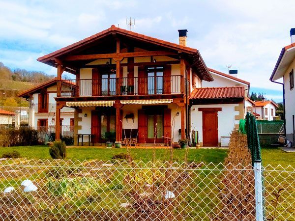 Una casa grande con una valla delante