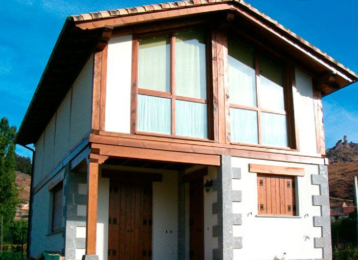 Una casa blanca con techo de madera y muchas ventanas