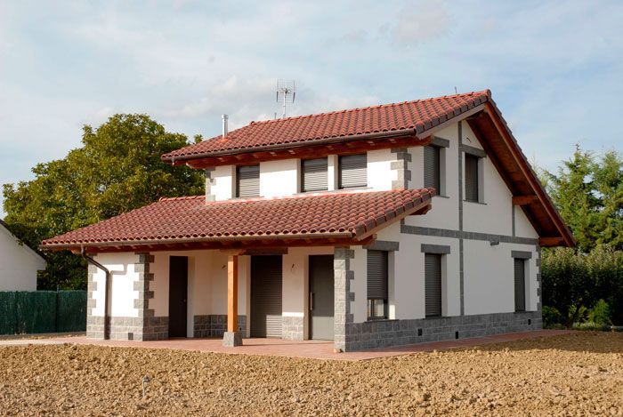 Una casa blanca con techo de tejas rojas