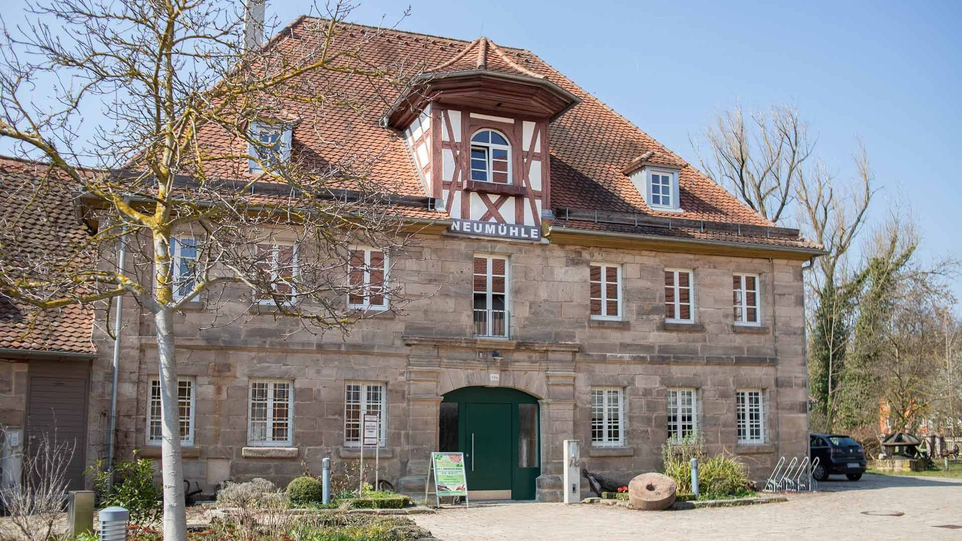 Altes Steingebäude mit rotem Ziegeldach und grünem Bogeneingang, im Tageslicht gesehen