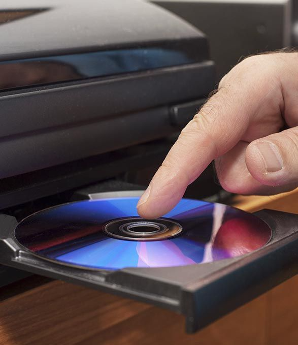 Una persona está poniendo un CD en un reproductor.
