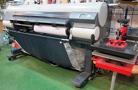 Una impresora grande está colocada encima de una mesa en una habitación.