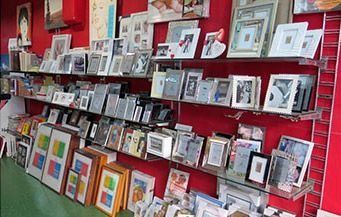 Una tienda llena de cuadros en los estantes.