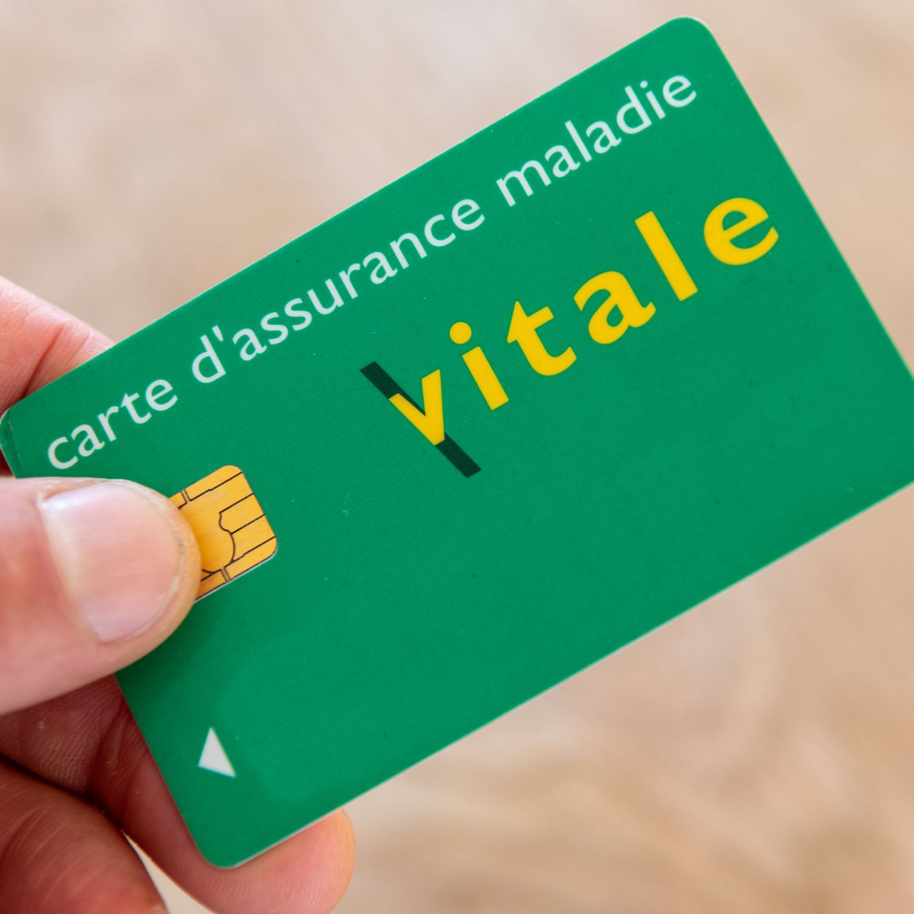 Main tenant une carte verte française d'assurance maladie carte Vitale.