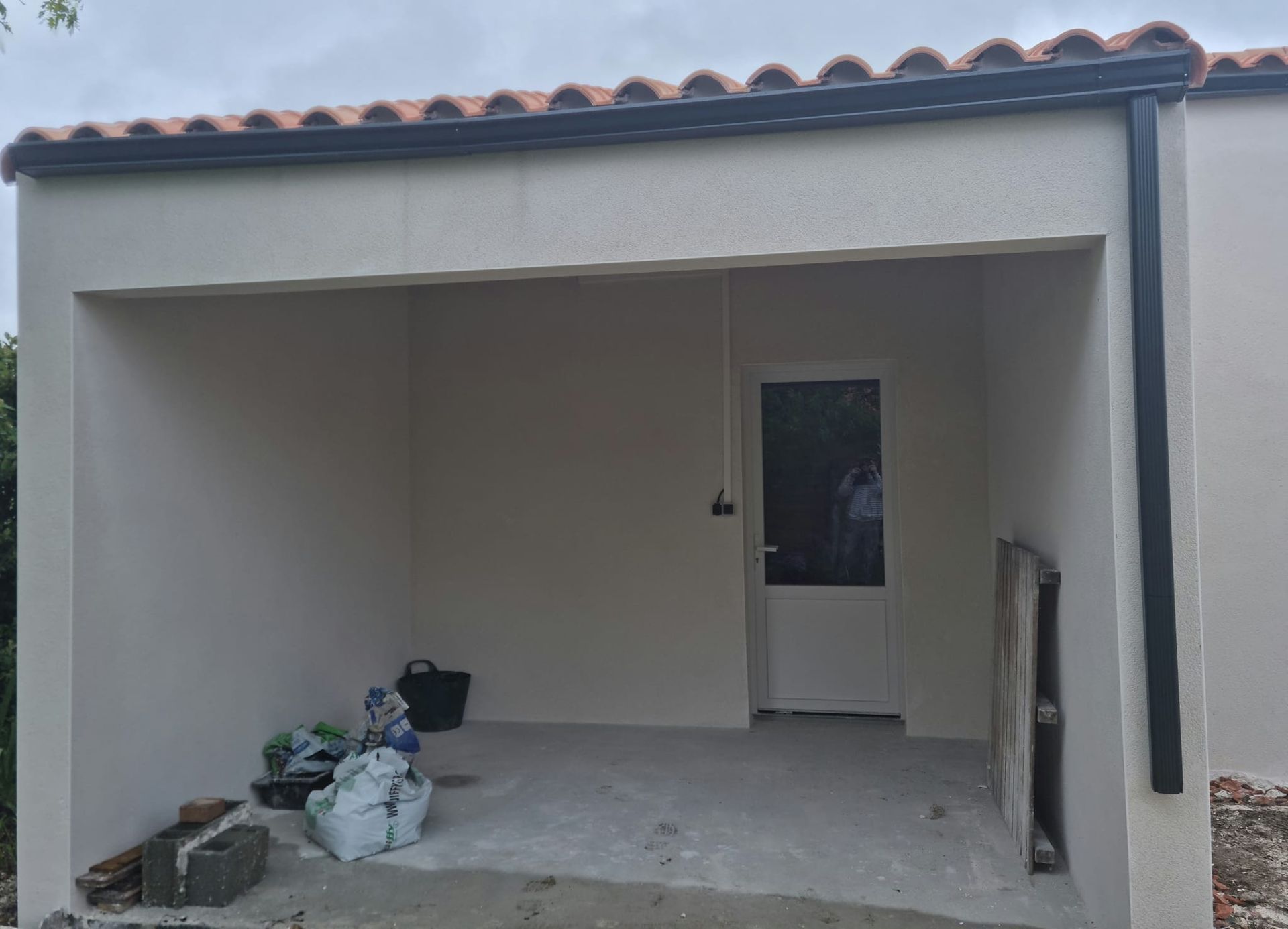 Une entrée sous un auvent et des affaires au sol