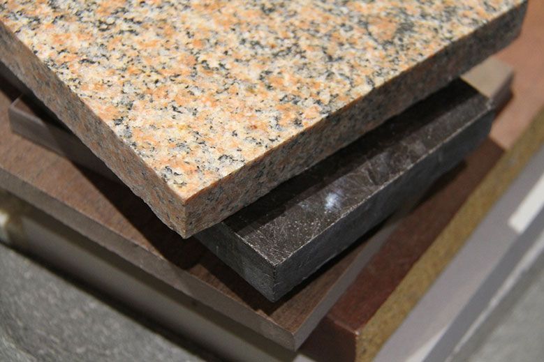 Pile d'échantillons de pierres de différentes couleurs et de matériaux composites.