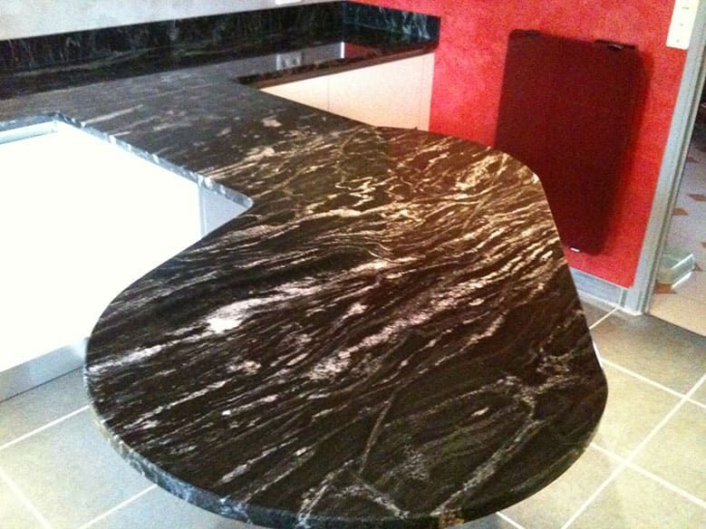 Plan de travail en granit noir veiné de blanc ; ambiance cuisine.