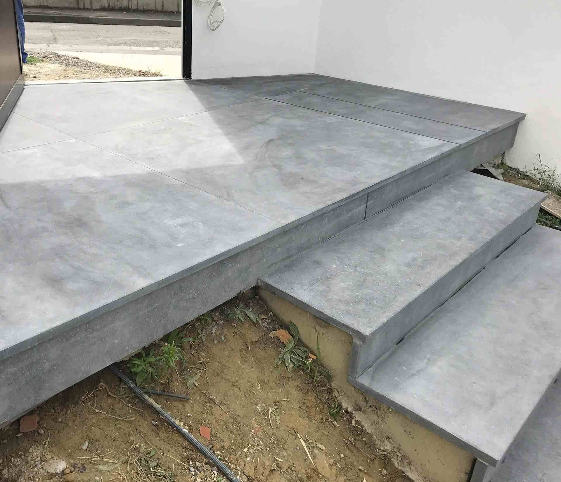 Des marches en béton et une aire de palier à l'extérieur d'un bâtiment.