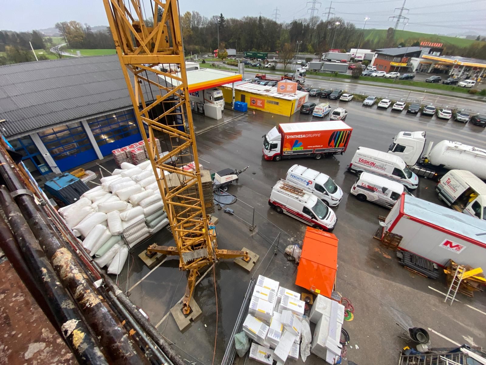 Eine Luftaufnahme einer Baustelle mit Lastwagen und einem Kran.