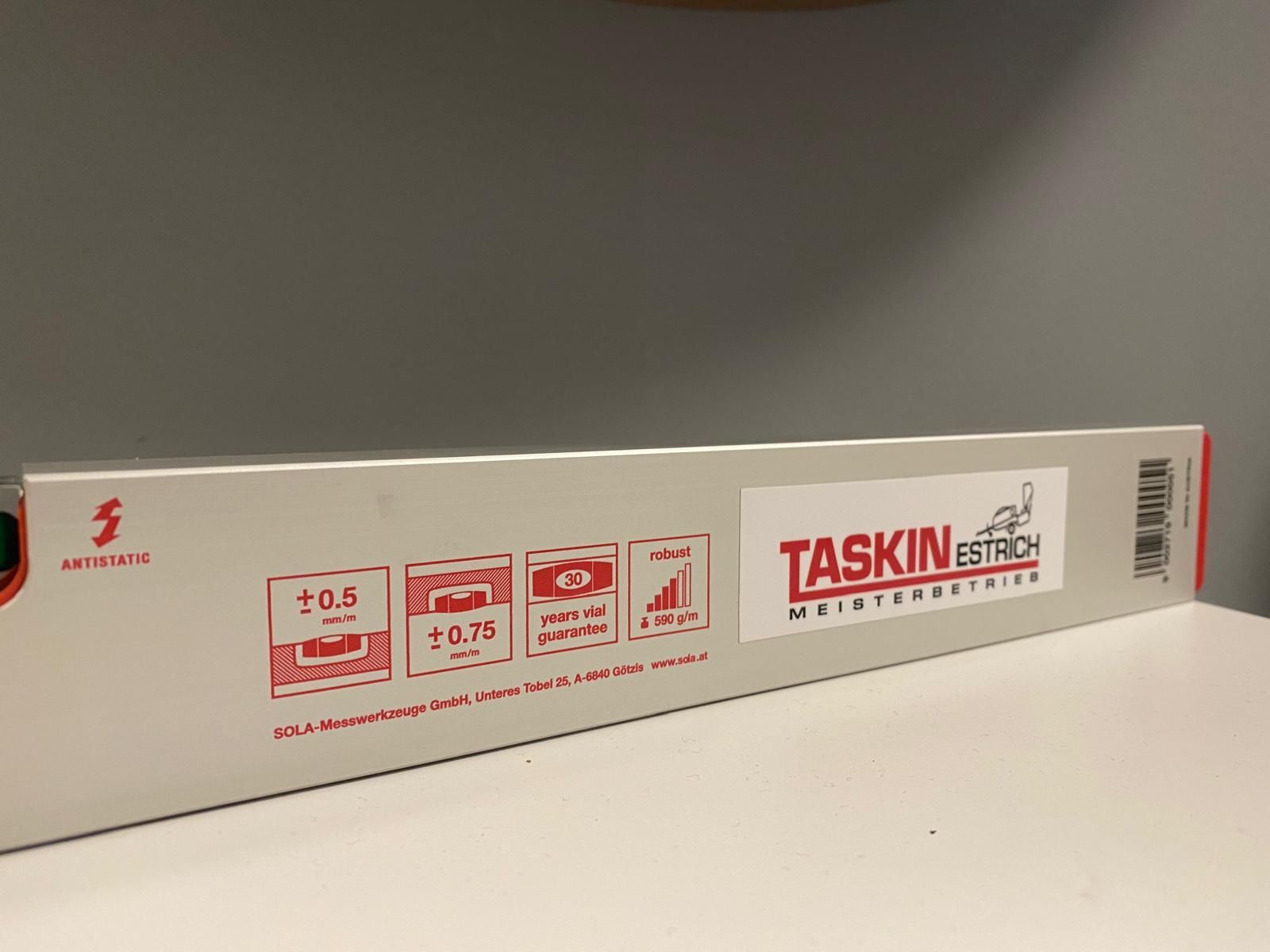 Eine weiße Schachtel mit einem roten Aufkleber darauf, auf dem steht: „Taskin“