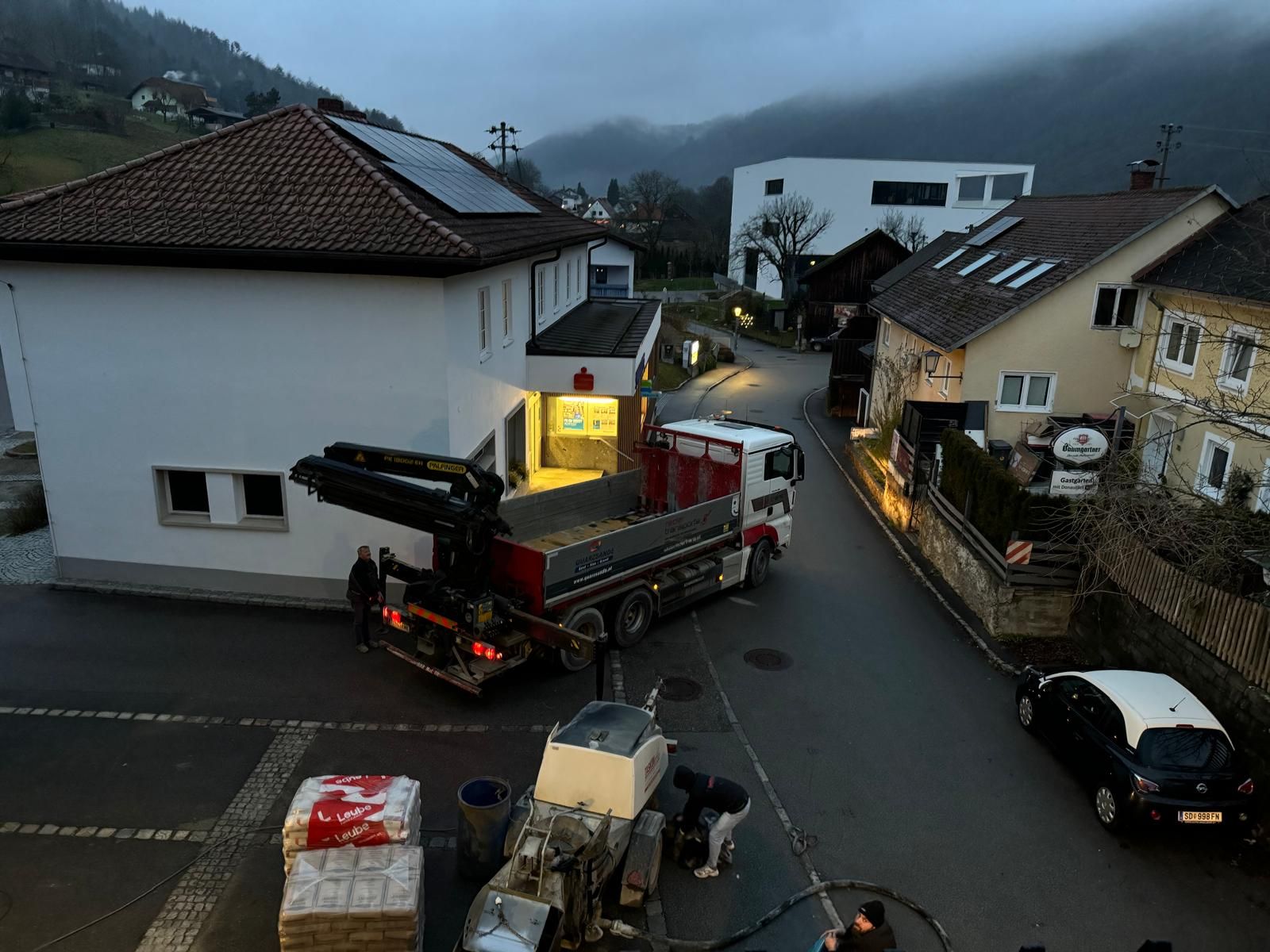 Ein Lastwagen fährt eine Straße vor einem Gebäude entlang.