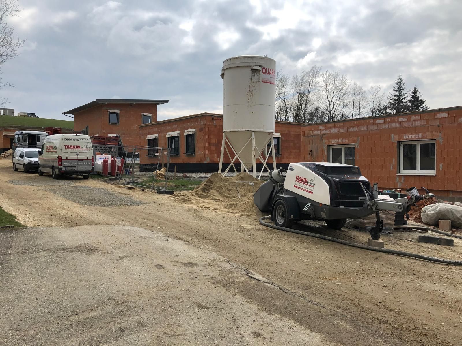 Eine Betonpumpe steht vor einem im Bau befindlichen Gebäude.