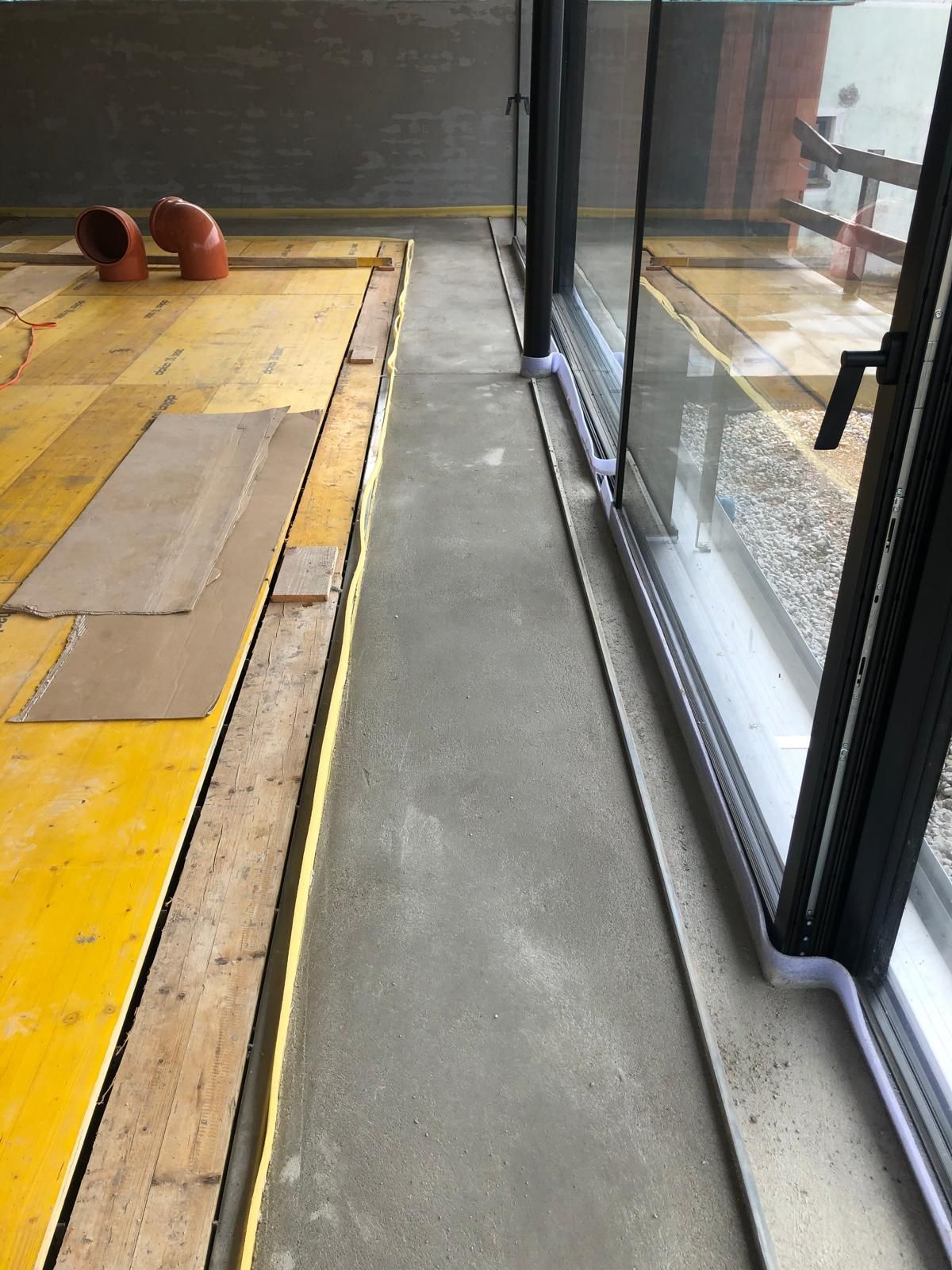 Ein Raum mit vielen Fenstern und Holzboden.