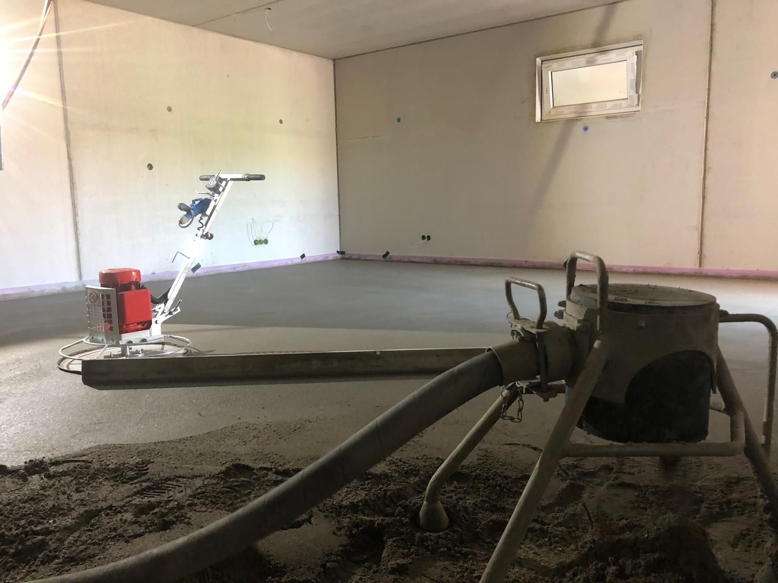 Mit einer Maschine wird Beton in einen Raum gegossen.