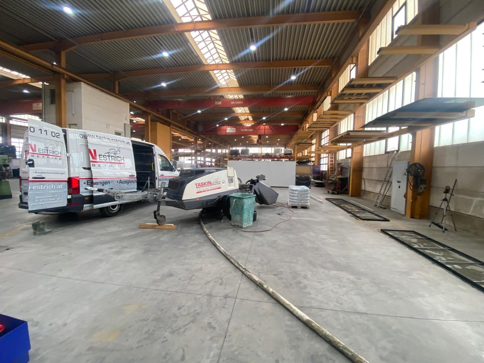 In einer großen Lagerhalle sind zwei Lieferwagen geparkt.