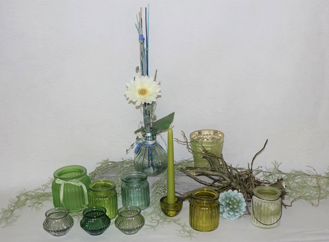 Dekoblume in einer Vase und Kerzen