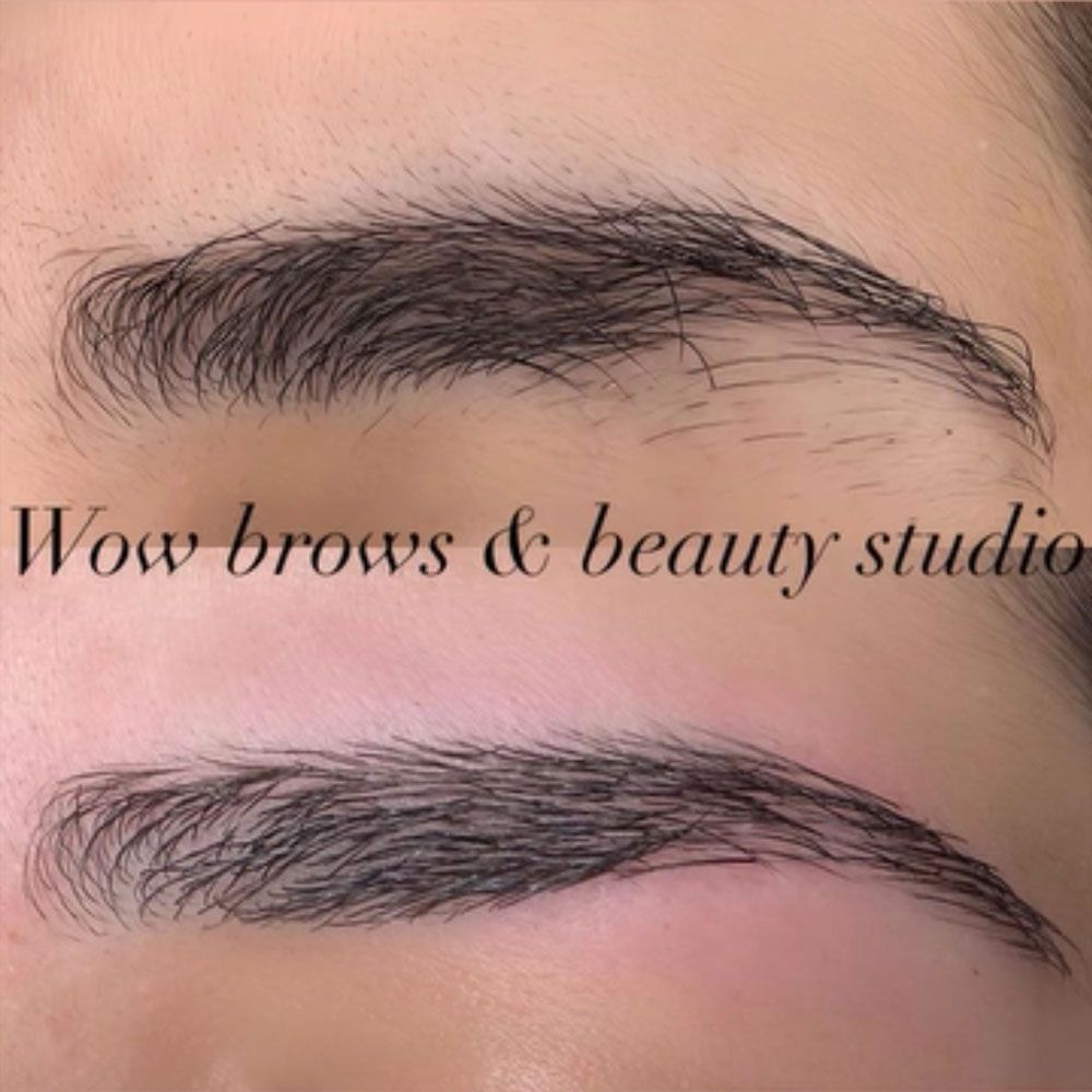 Nahaufnahme von zwei professionell gestylten Augenbrauen, dunkelbraunes Haar, mit dem Text „Wow brows & beauty studio“.