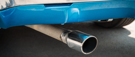 Um close de um carro azul com um cano de escapamento de aço inoxidável.