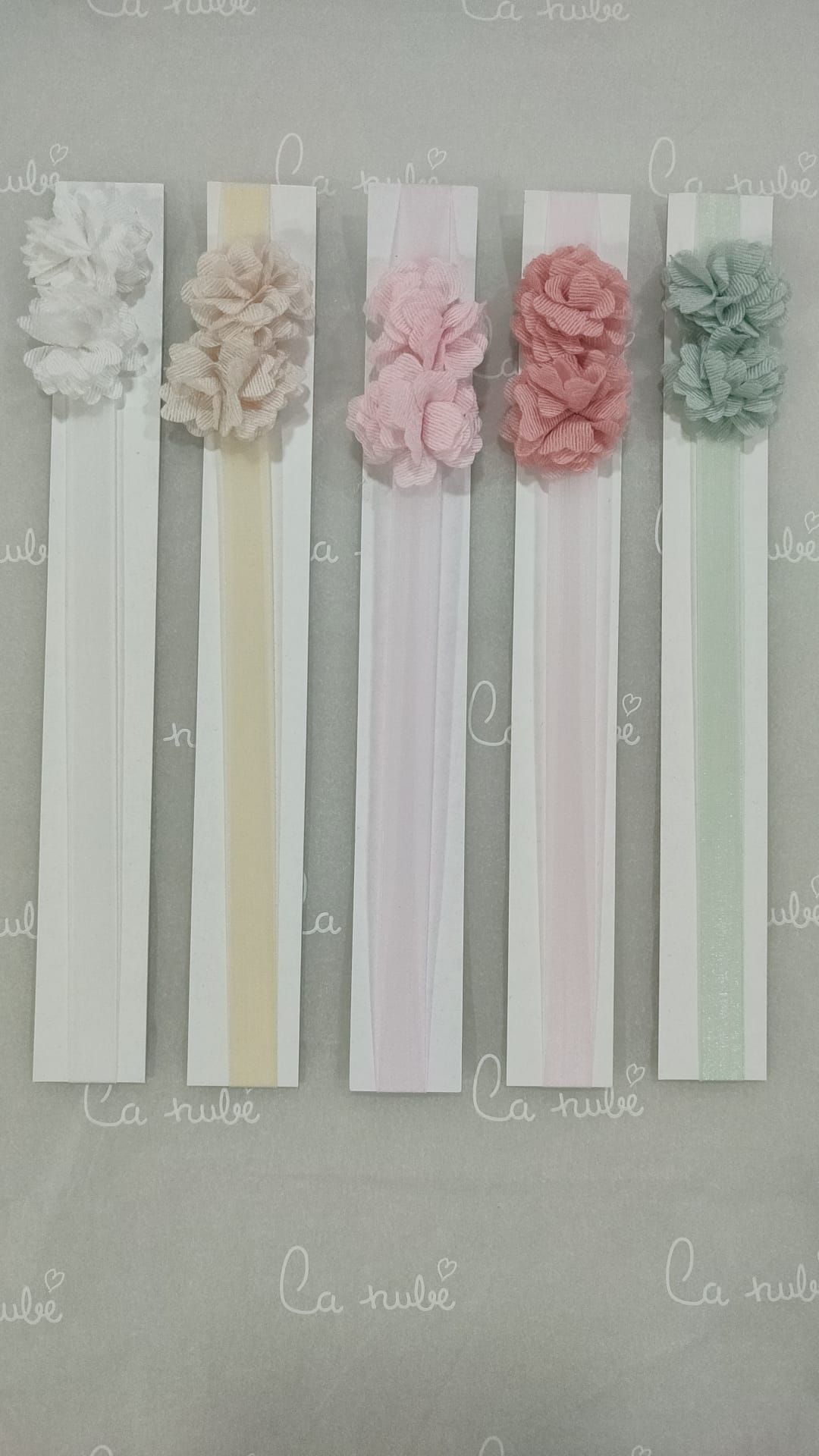 Una fila de diademas con flores están alineadas sobre una mesa.