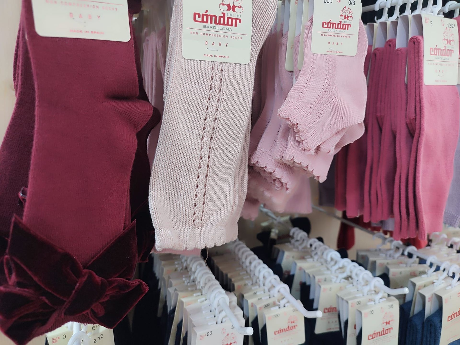 Un montón de calcetines están colgados en un estante en una tienda.