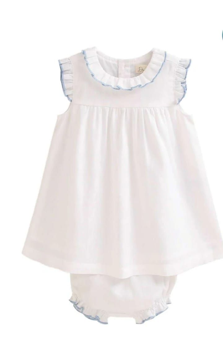Una niña lleva un vestido blanco y un pañal.