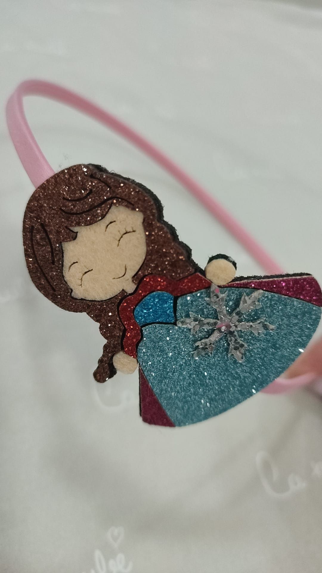 Una diadema rosa con una princesa en ella.