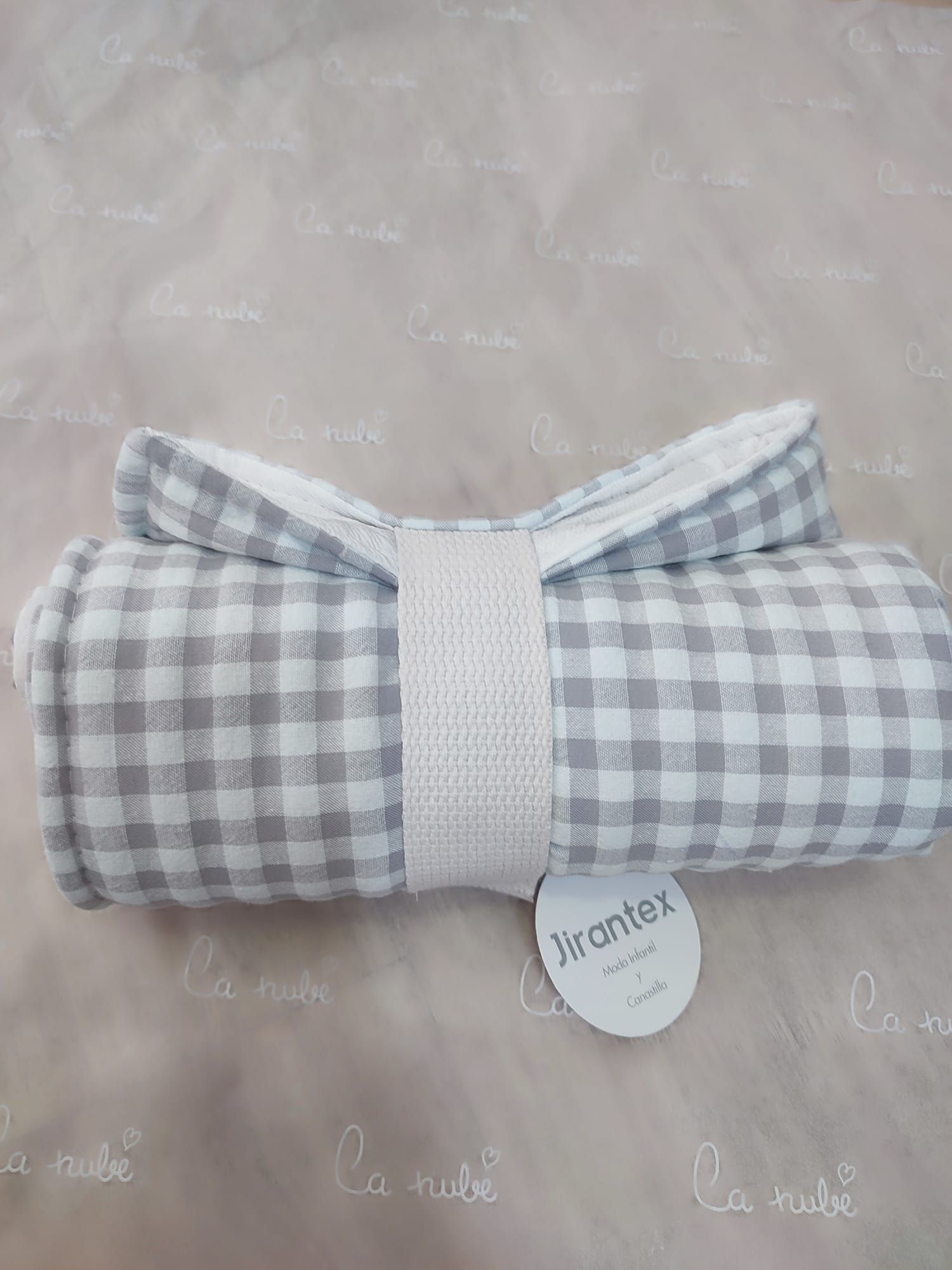 Una manta a cuadros grises y blancos está sobre una mesa.