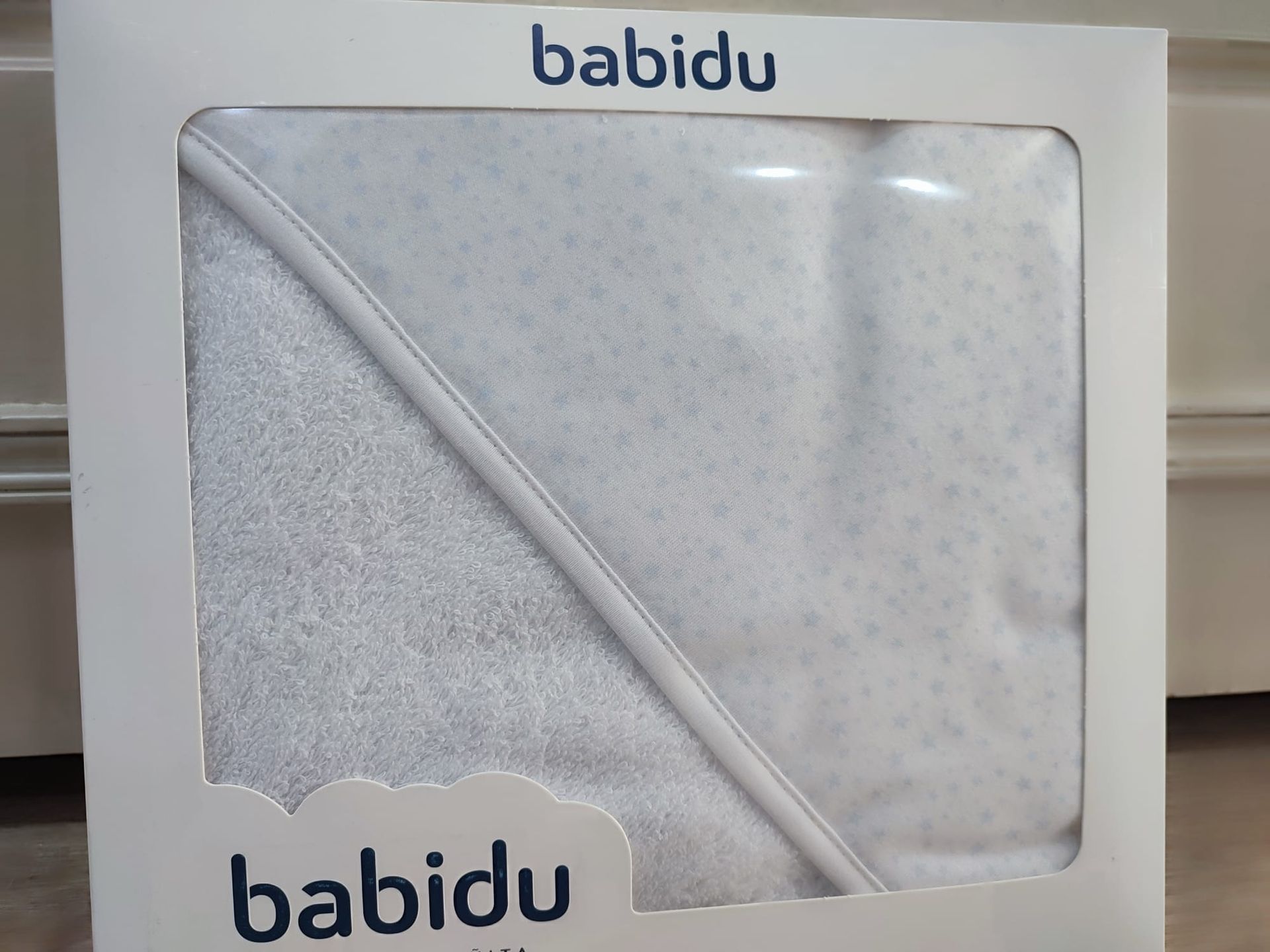 Una toalla blanca en una caja que dice babidu
