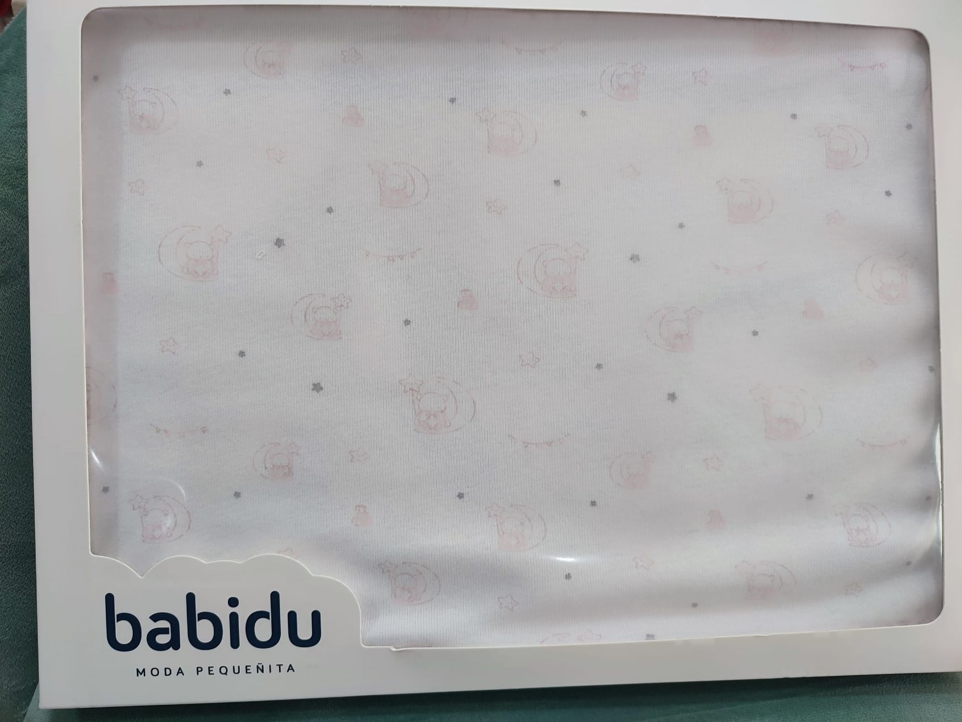 Hay una manta de bebé blanca en una caja con la palabra babidu escrita en ella.