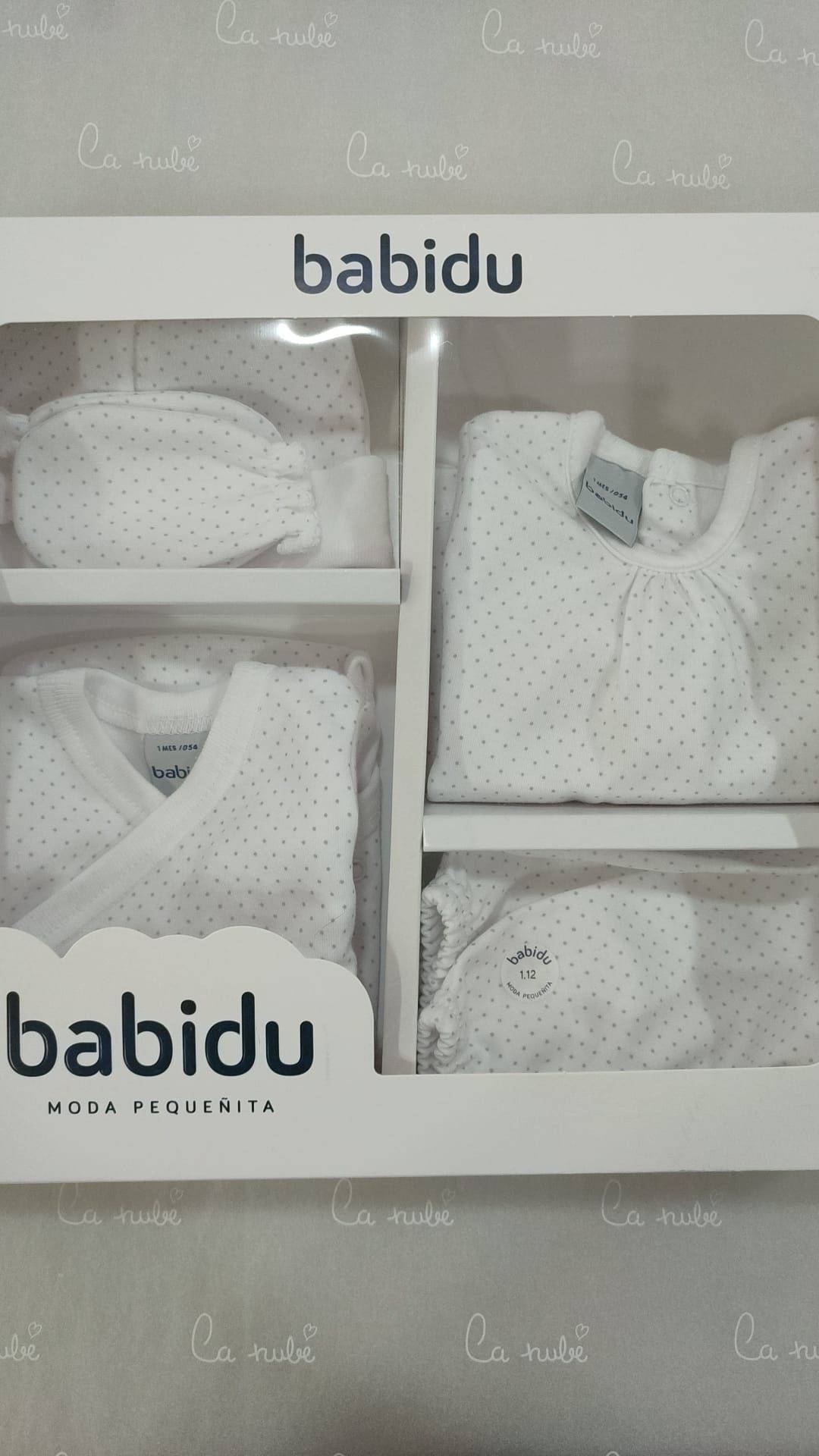 Una caja de ropa de bebé babidu está sobre una mesa.