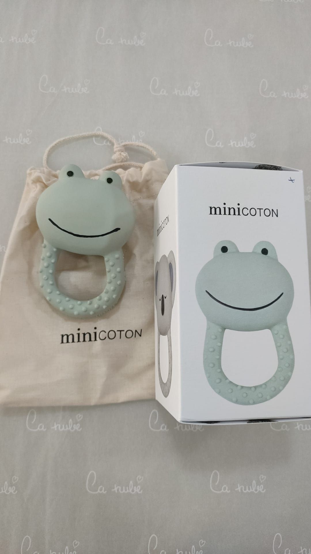 Un anillo de dentición de rana está junto a una caja sobre una mesa.