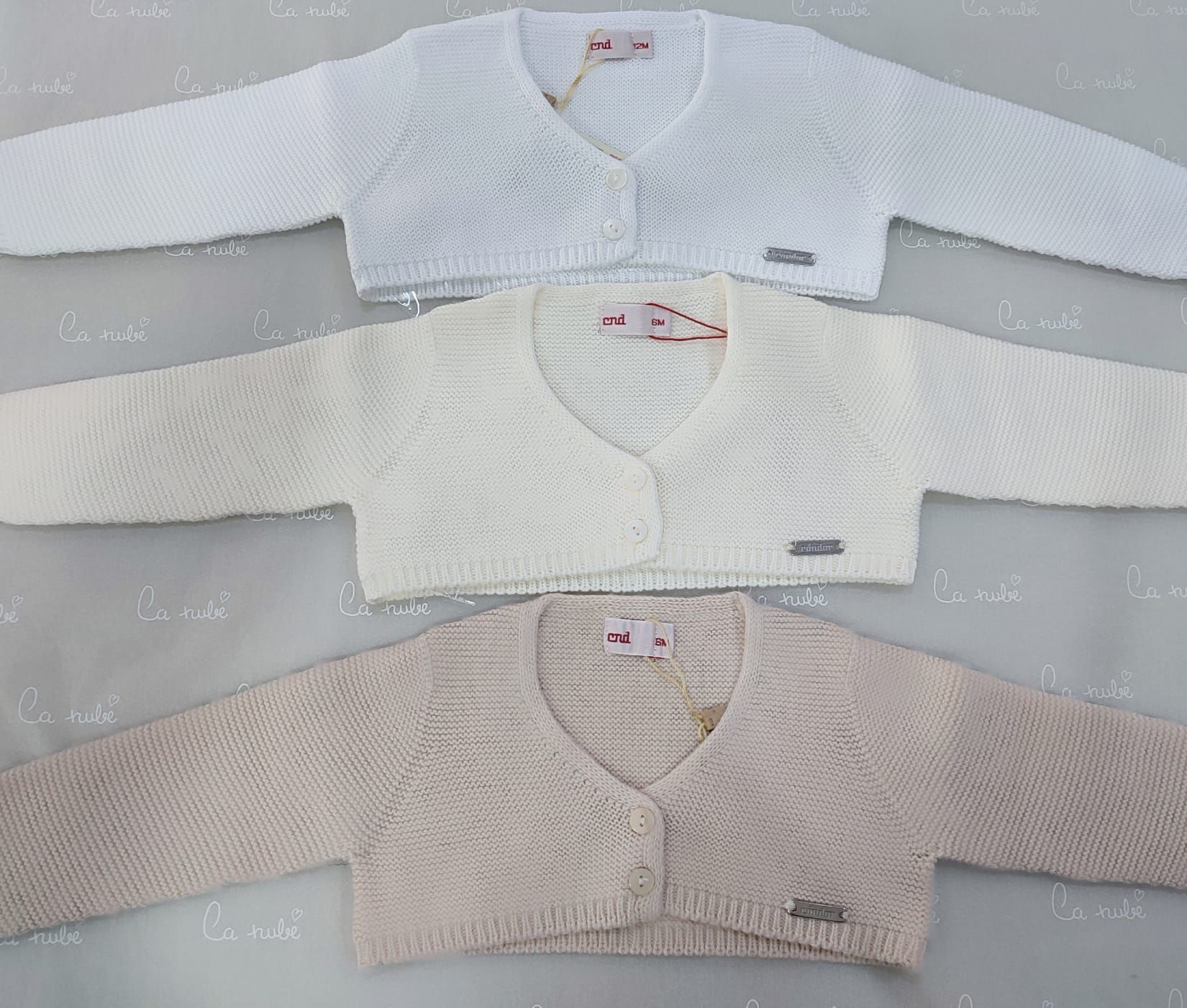 Tres suéteres están colocados uno encima del otro sobre una mesa.