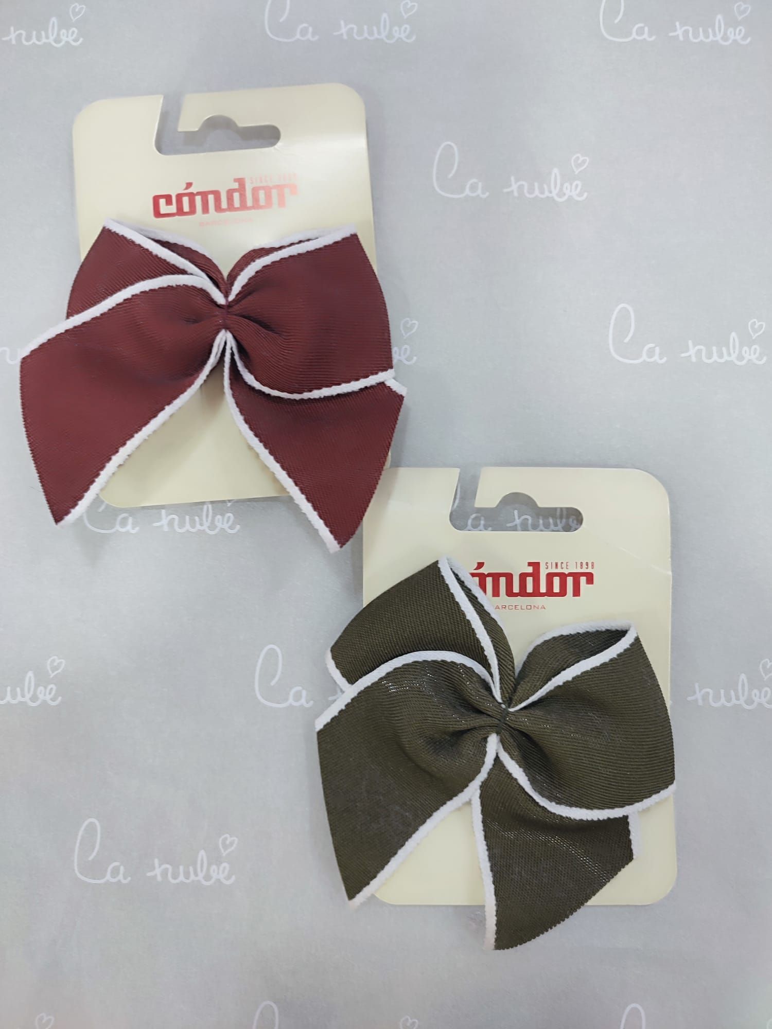 Dos moños para el cabello están en una tarjeta que dice cóndor